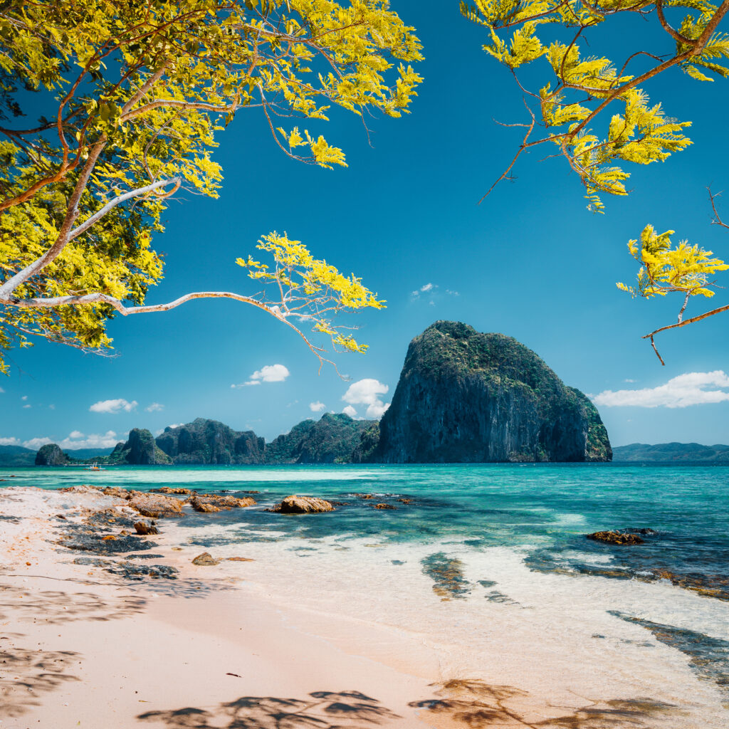 Beautiful landscape scenery of El Nido coastline. Unique amazing Pinagbuyutan island in background framed by tree branches. Palawan, Philippines.